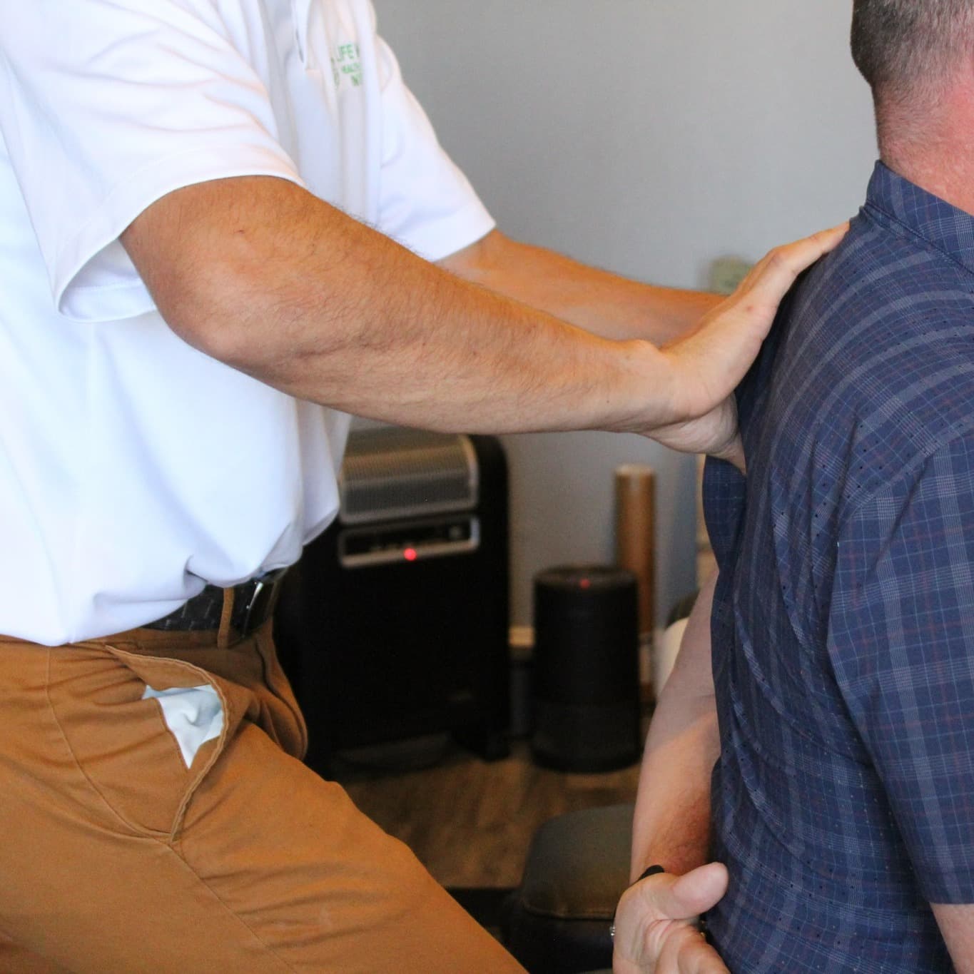 Alameda chiropractor assessing a client's spine before an adjustment at Rise Bodyworks